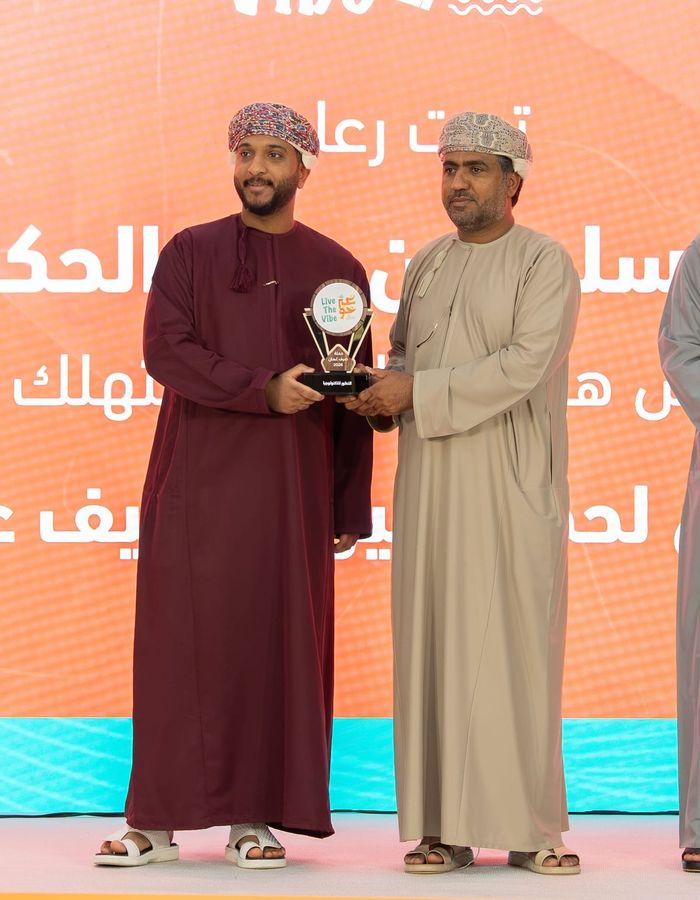 LVLUP founder Sulaiman Al Sinawi (left) receives the Live The Vibe 2026 award from H.E. Sulayem Al Hakmani, Chairman of the Consumer Protection Authority, on stage at the campaign’s ceremony.